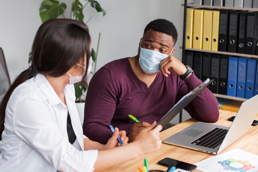 A doctor consulting a patient and reviewing his reports together.