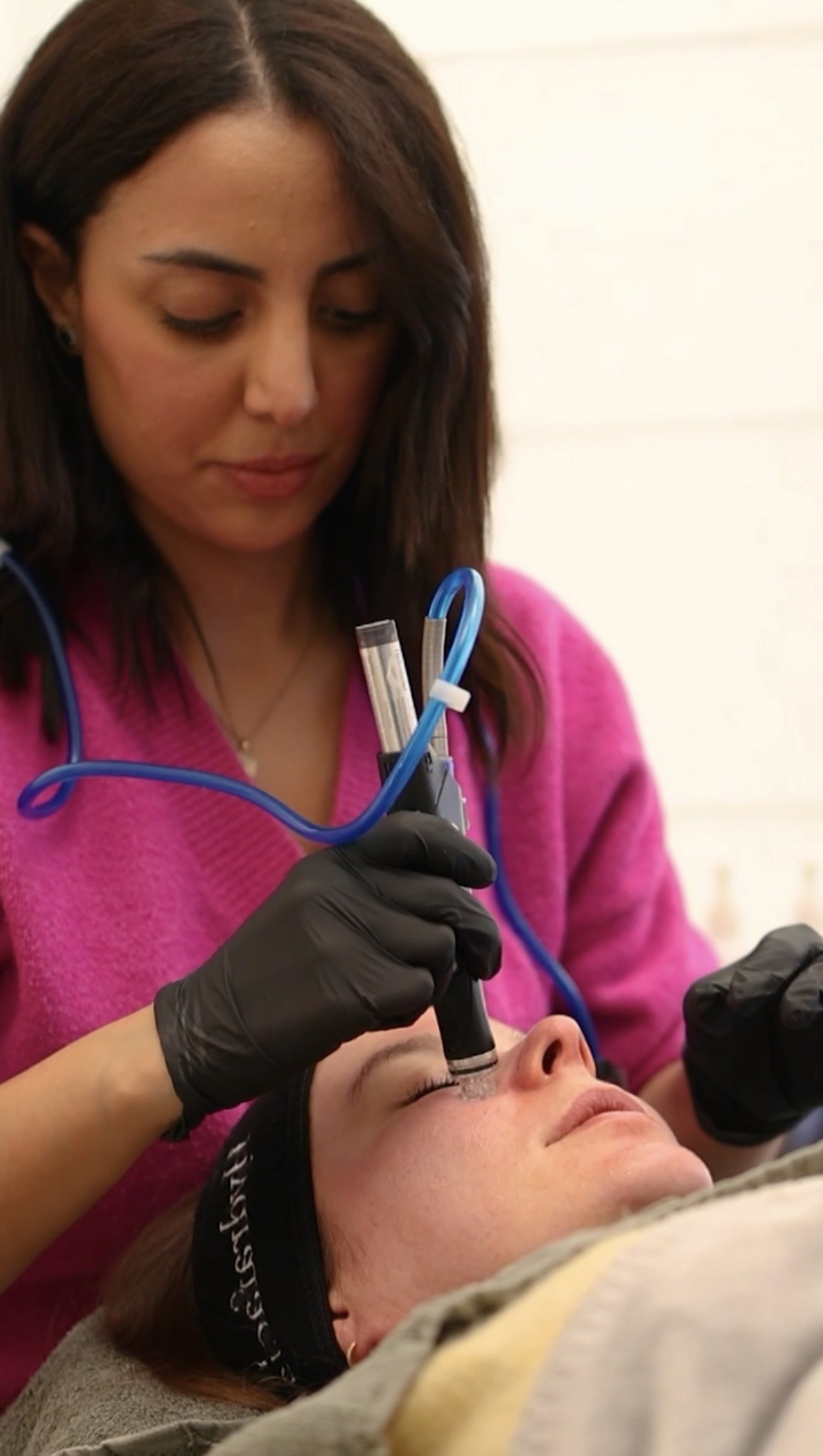 Aesthetic nurse Yassmin Boualam performing a Hydrafacial treatment on Dr. Louise Cuveele