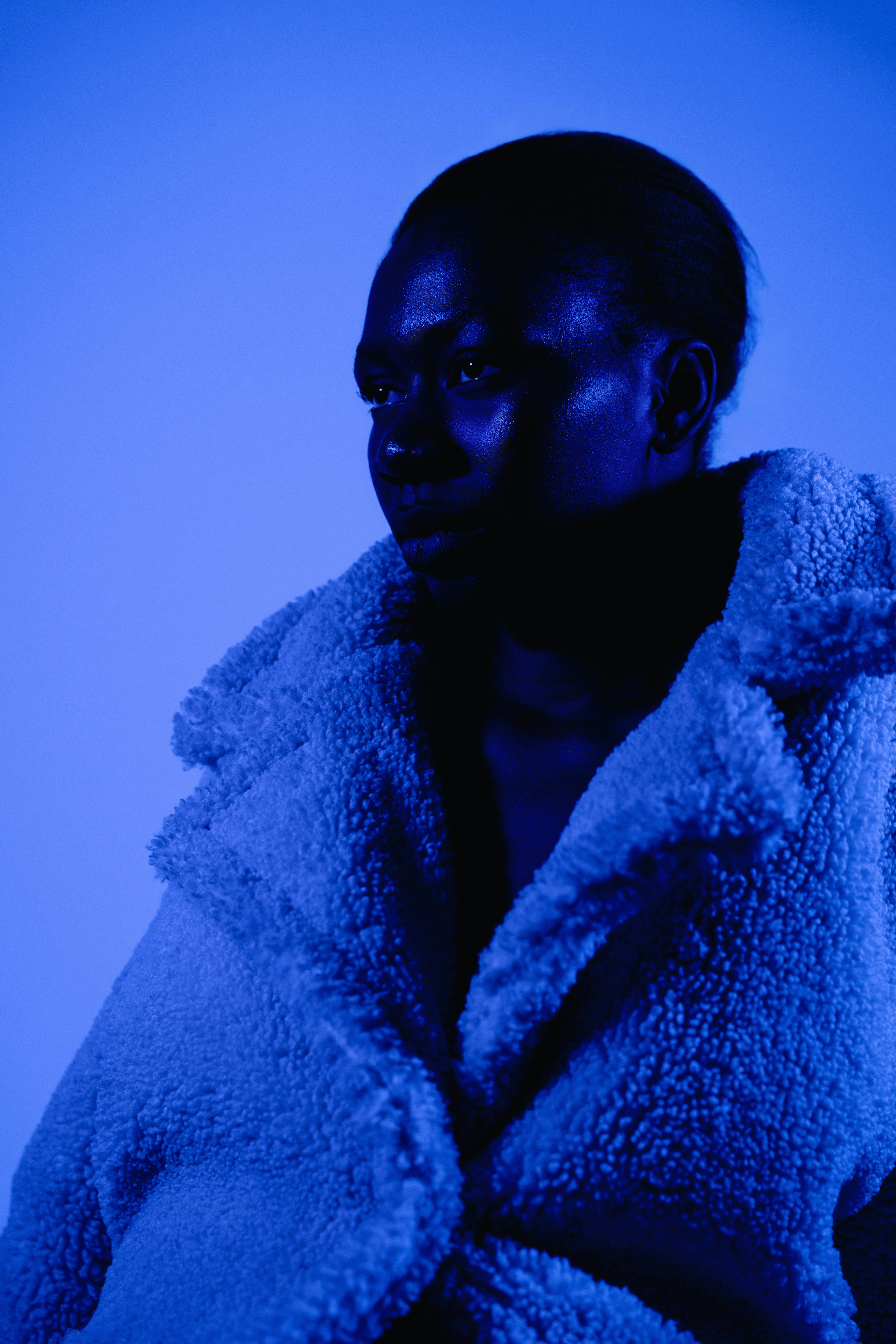 Woman wears a blue coat in a blue environment.