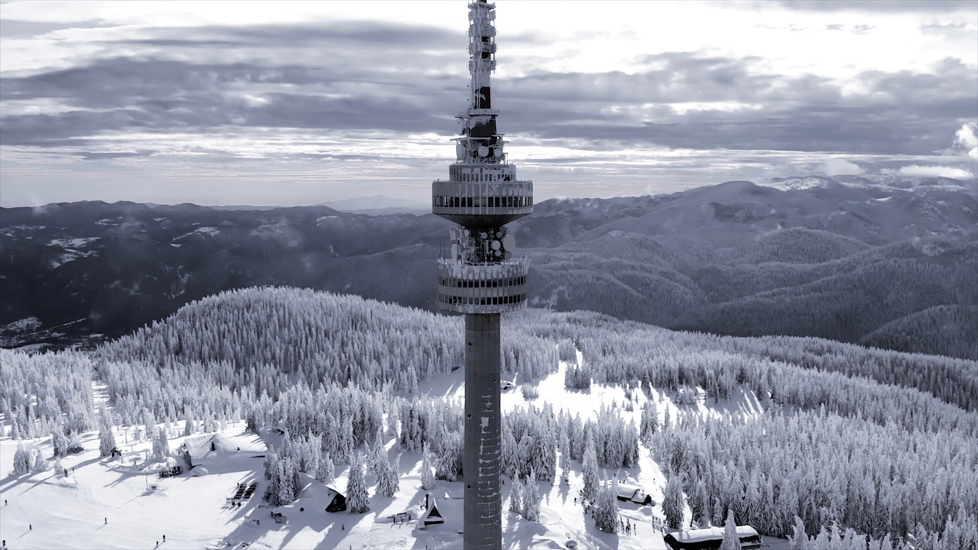 Snow-covered Bansko resort and forested mountain slopes