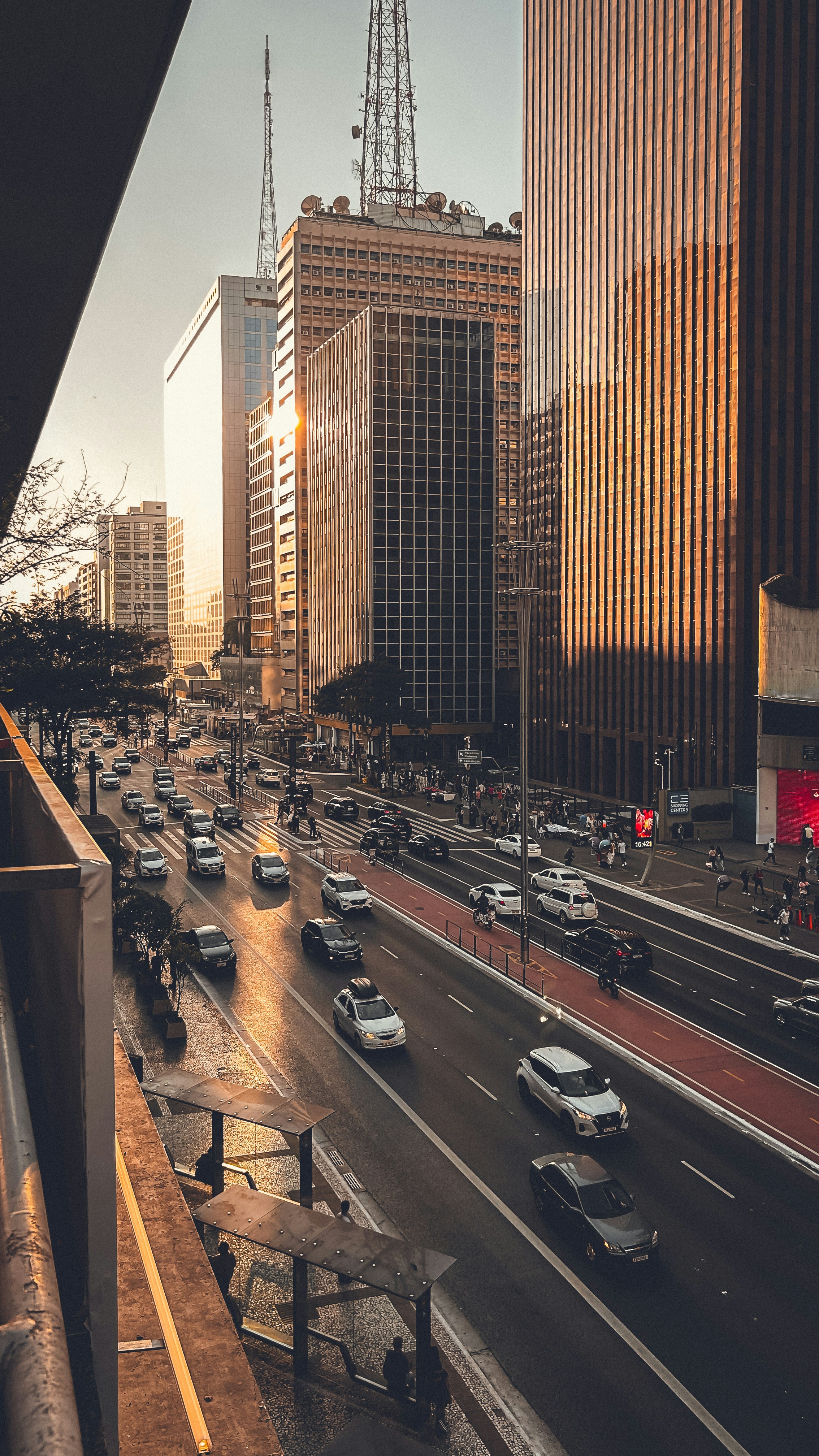 A city street filled with lots of traffic next to tall buildings