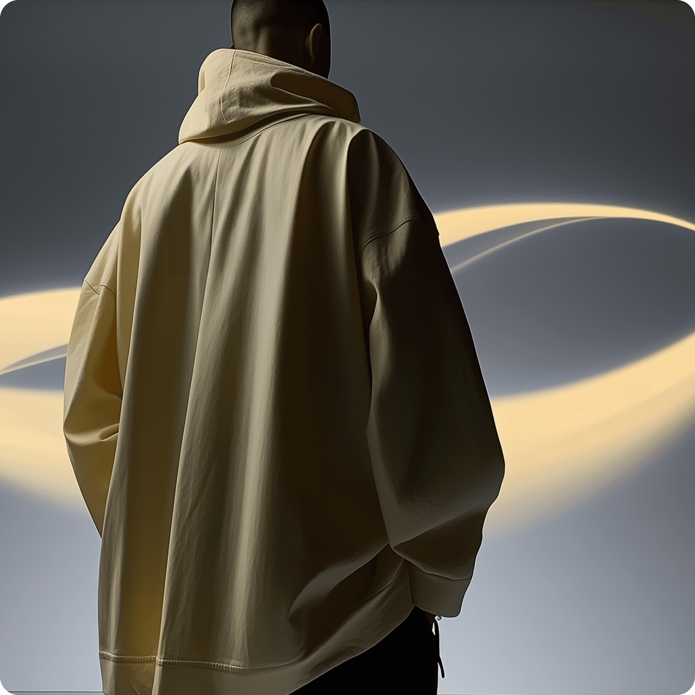 Person seen from behind in a light-yellow hoodie against a studio backdrop.
