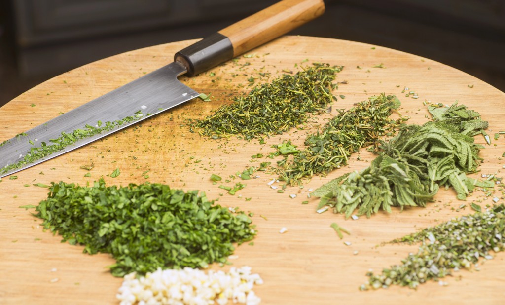 Minced and chopped herbs on cutting board