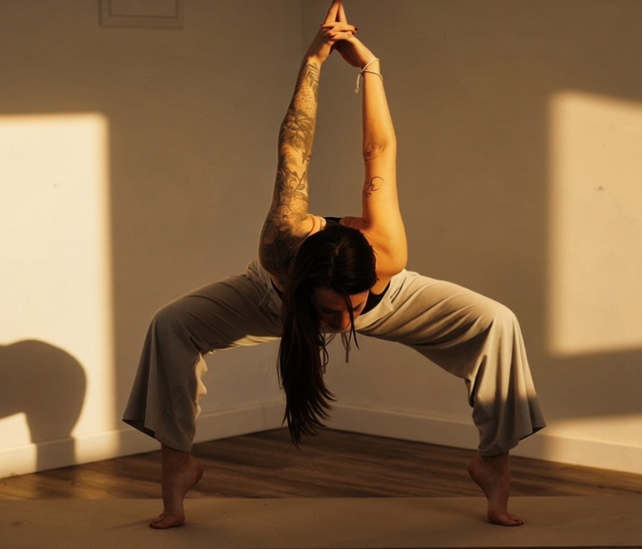 Professeure de yoga en posture de l'étoile filante, bras tendus vers le haut dans un studio de yoga