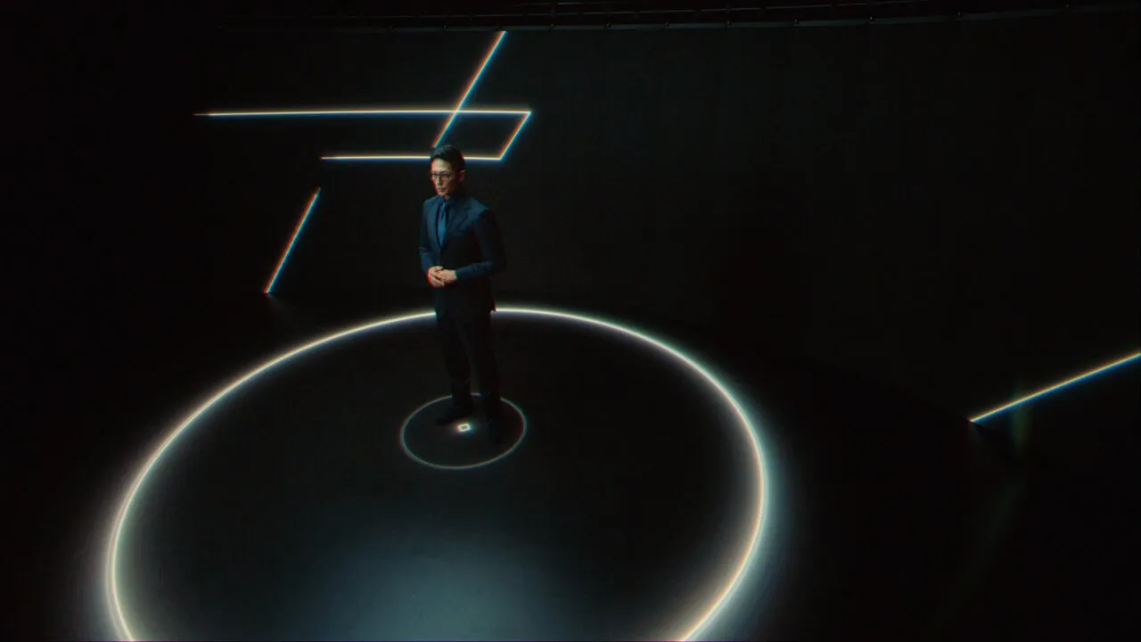 A man standing in the center of a stage promoting Tokai Optical lenses