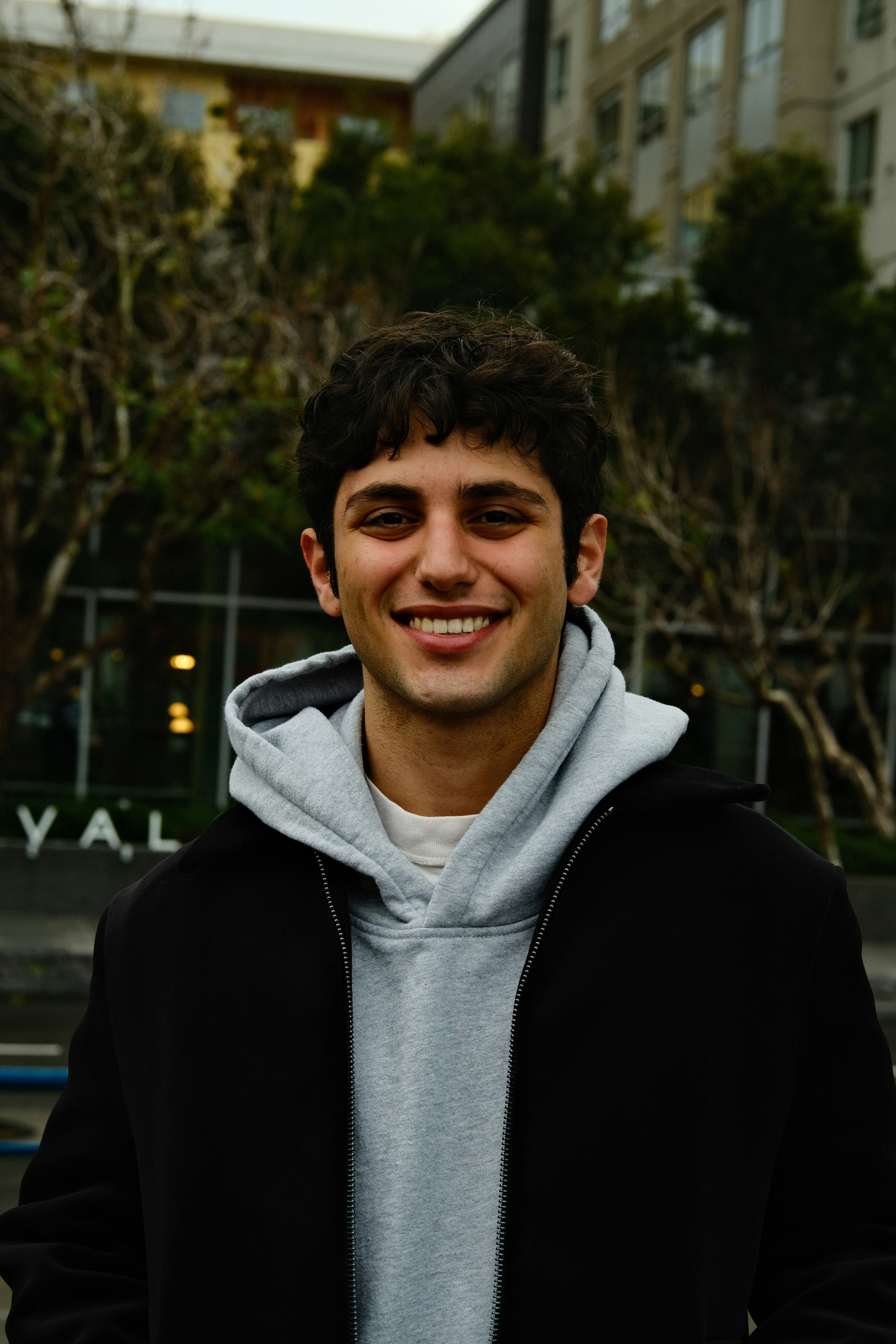 A young man standing in front of a building