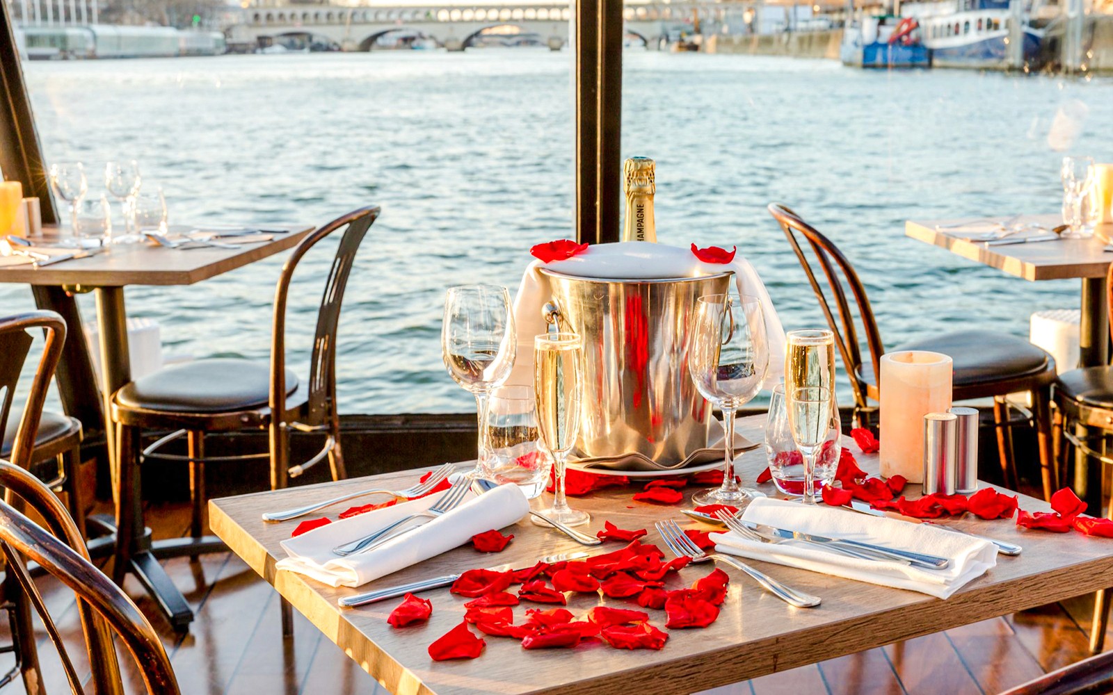 Tafel gedekt met champagne en rozenblaadjes tijdens een cruise op de Seine.