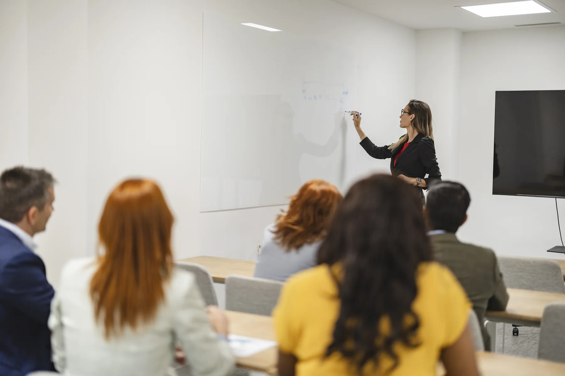 Business Presentation with Woman Presenter at Whiteboard