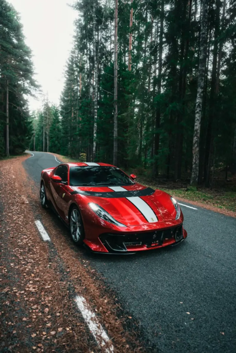 Roter Ferrari 812 GTS auf Landstraße im Herbst – Supersportwagen Versicherung All-Risk Kasko | Lions Group
