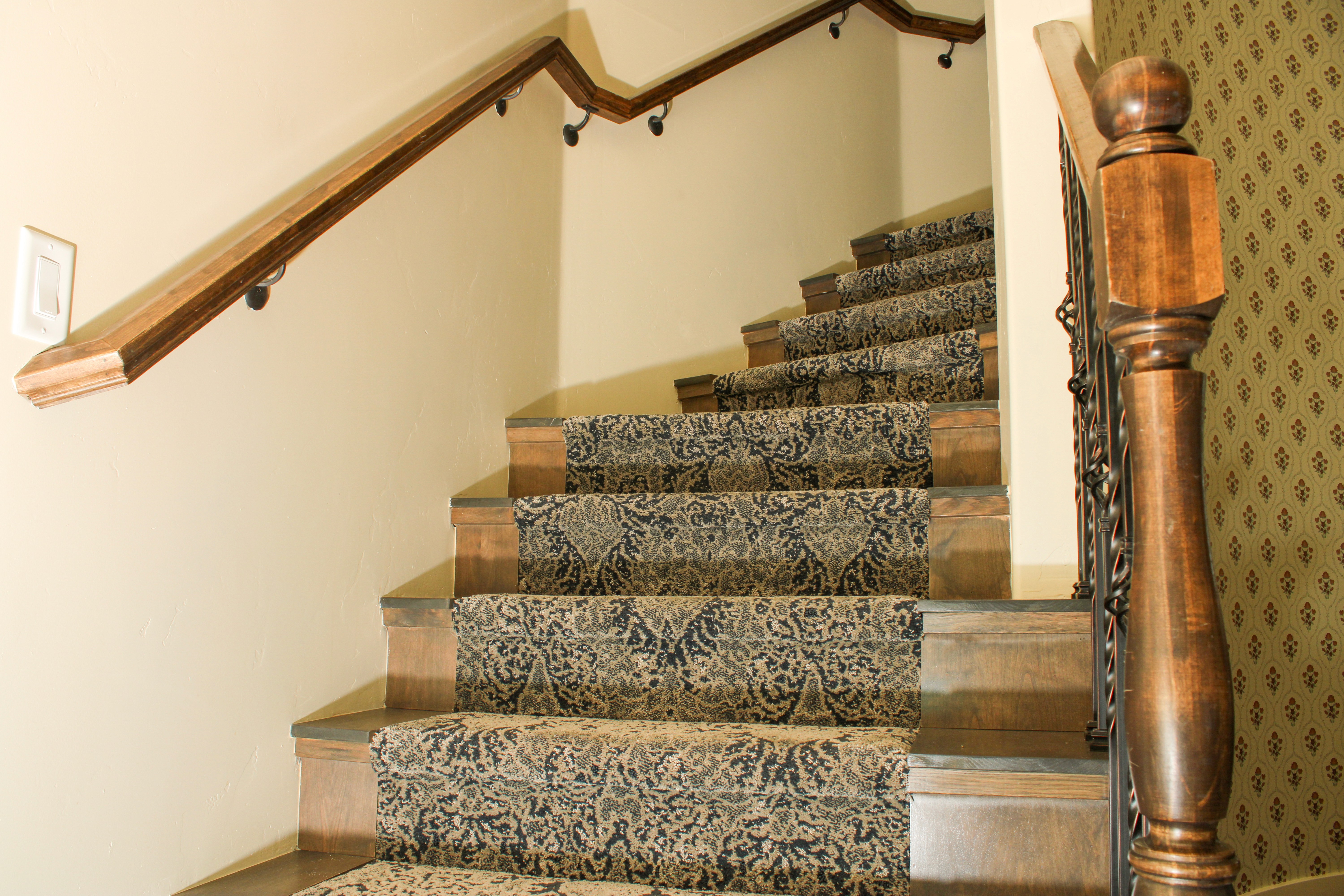 Carpeted staircase with wood-finished sides in a Washington, Utah home remodel, combining comfort and craftsmanship