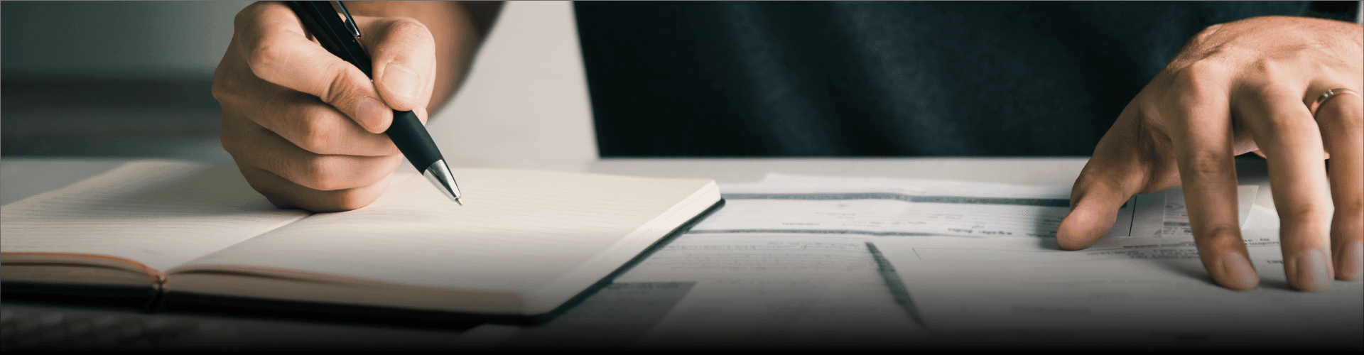 Person writing notes while reviewing financial documents - Financial Report Writing