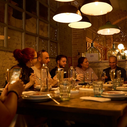 一群人在巴塞罗那的波恩区一个温馨、诱人的餐厅环境中享受晚餐体验。