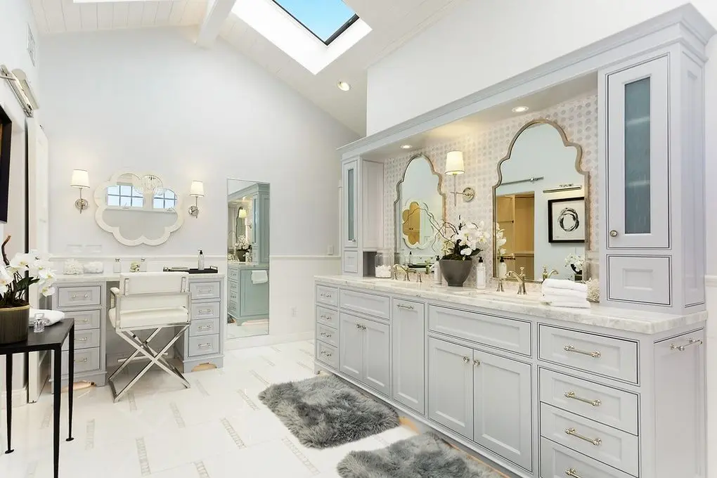 'Port Streets Remodel' bathroom with dual vanity, ornate mirrors, skylight, and elegant white and gray decor.