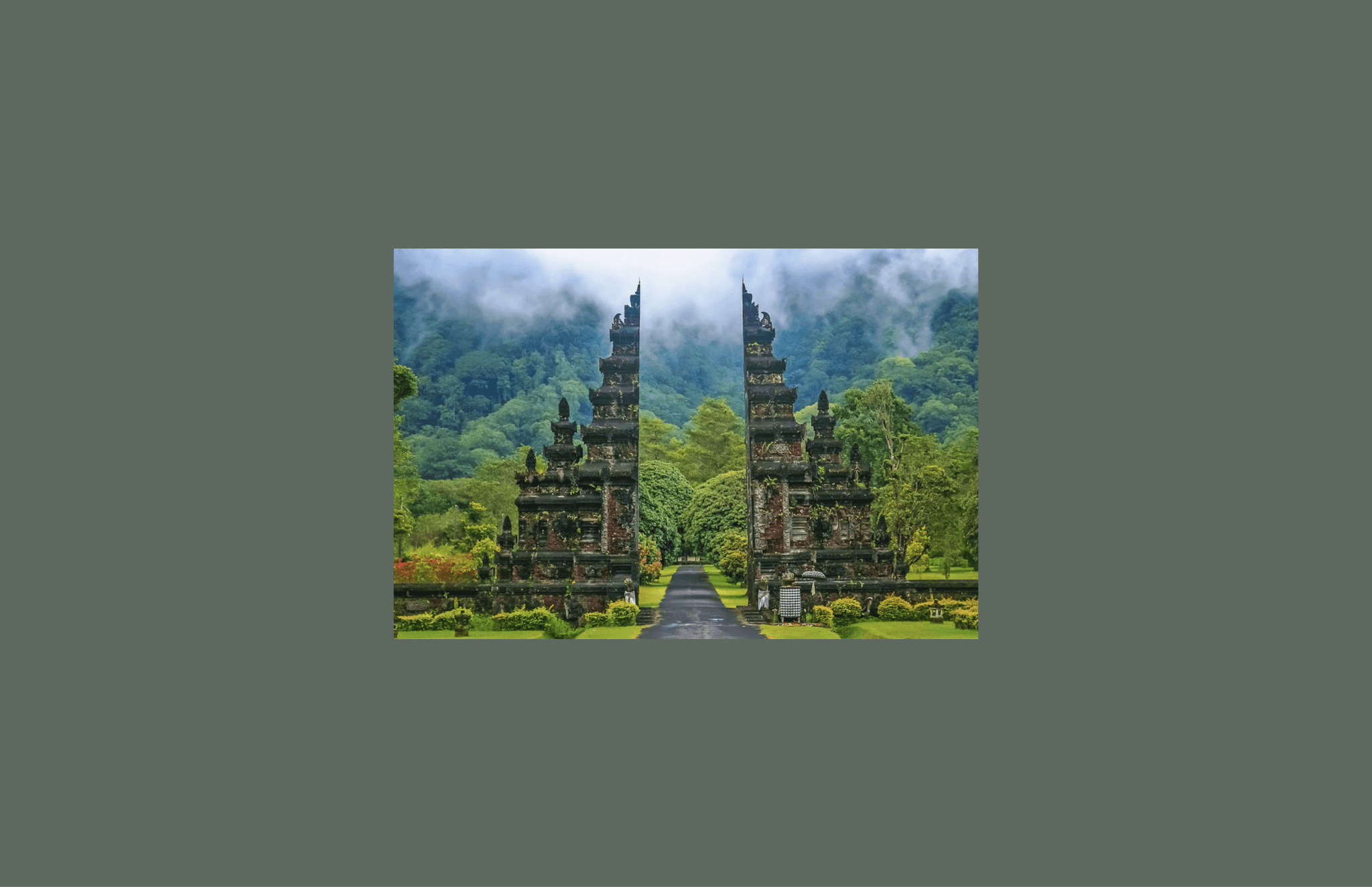 Traditional Balinese split gate framed by tropical forest and low cloud in the highlands.