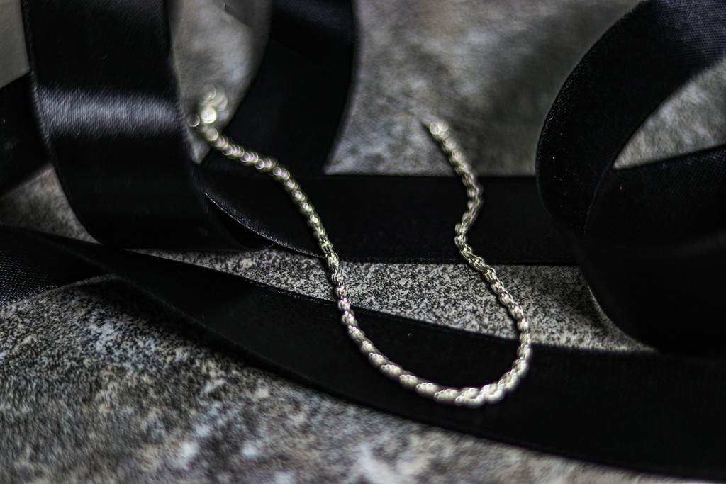 A pair of headphones sitting on top of a black ribbon