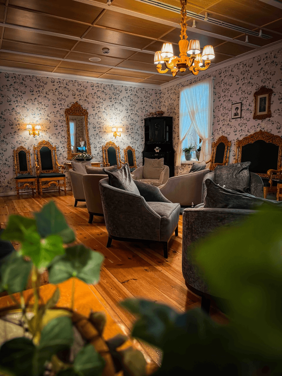 A cozy lounge area with comfortable chairs, warm lighting, and plants, creating an inviting atmosphere.