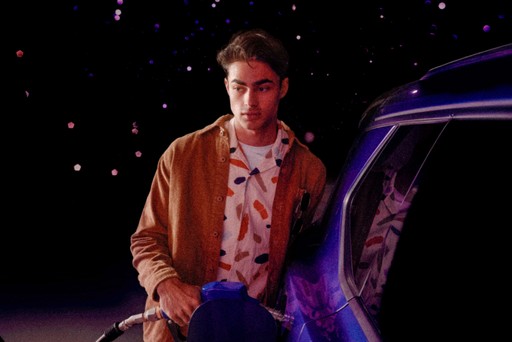 Young man at gas pump filling up car