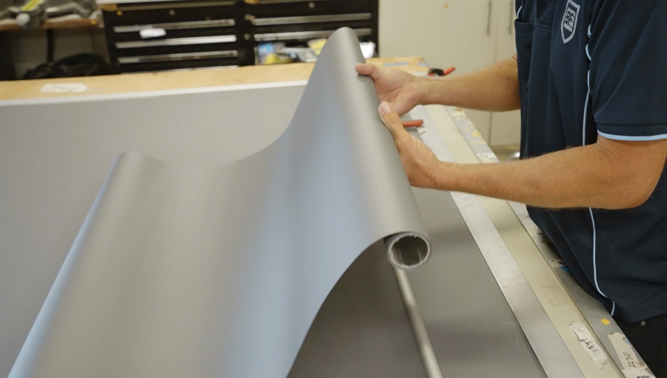 Technician assembling roller blind components during production