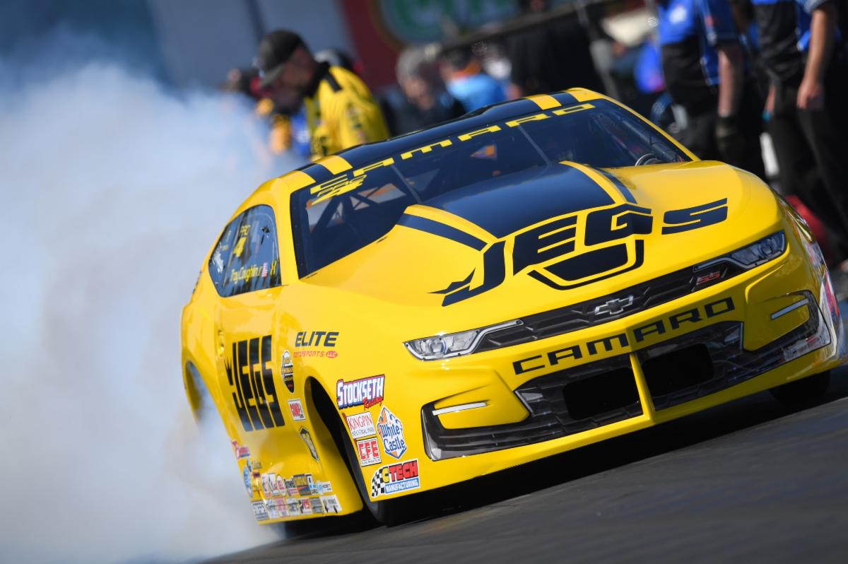 Scenic cabin interior with lake and forest view outside large window.