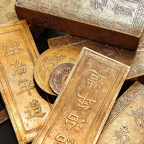 带有复杂雕刻和汉字的金条和金币。