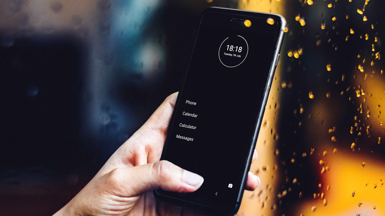 Smartphone with minimalist phone app by a rainy window