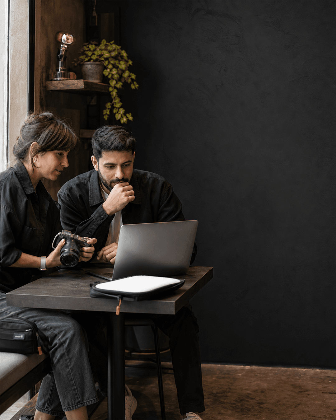 Two creative professionals reviewing photography beside a laptop