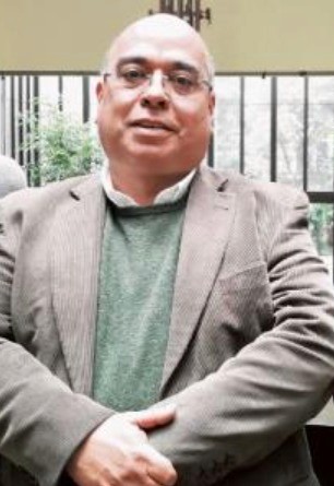 Aerial view of a winding road cutting through rocky terrain with patches of grass.