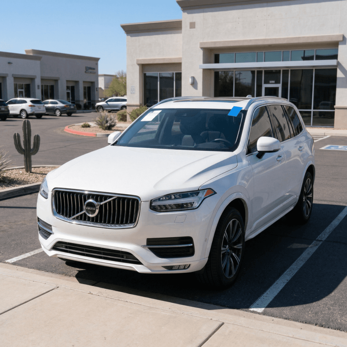 White Volvo XC90 with a like-new windshield replacement at a Sedona, Arizona commercial plaza
