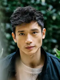 Manny Jacinto headshot in front of leaves