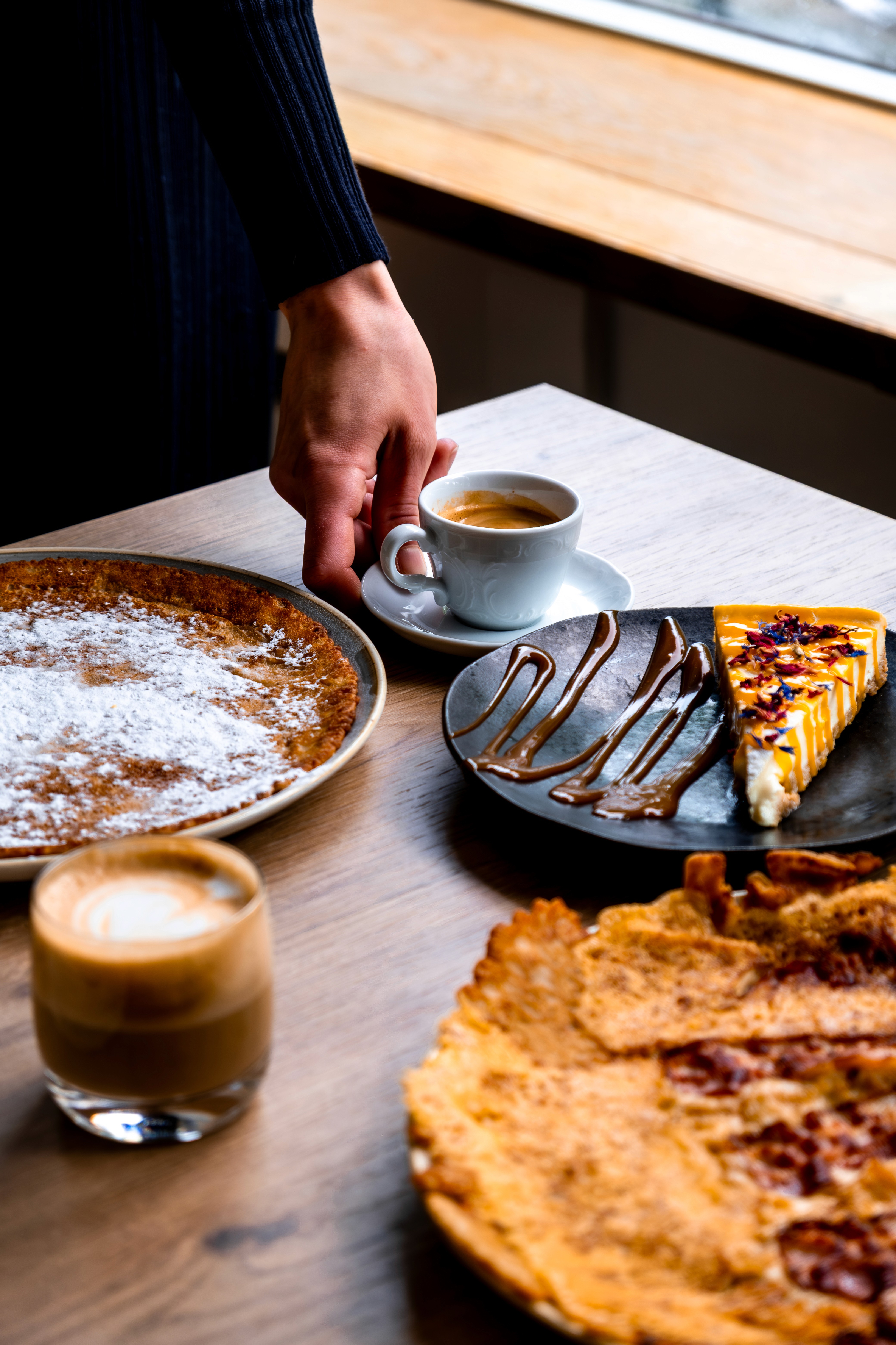 Verse pannenkoeken, lemon cheesecake  en koffie op tafel bij Pan & Cook in Prinsenbeek.