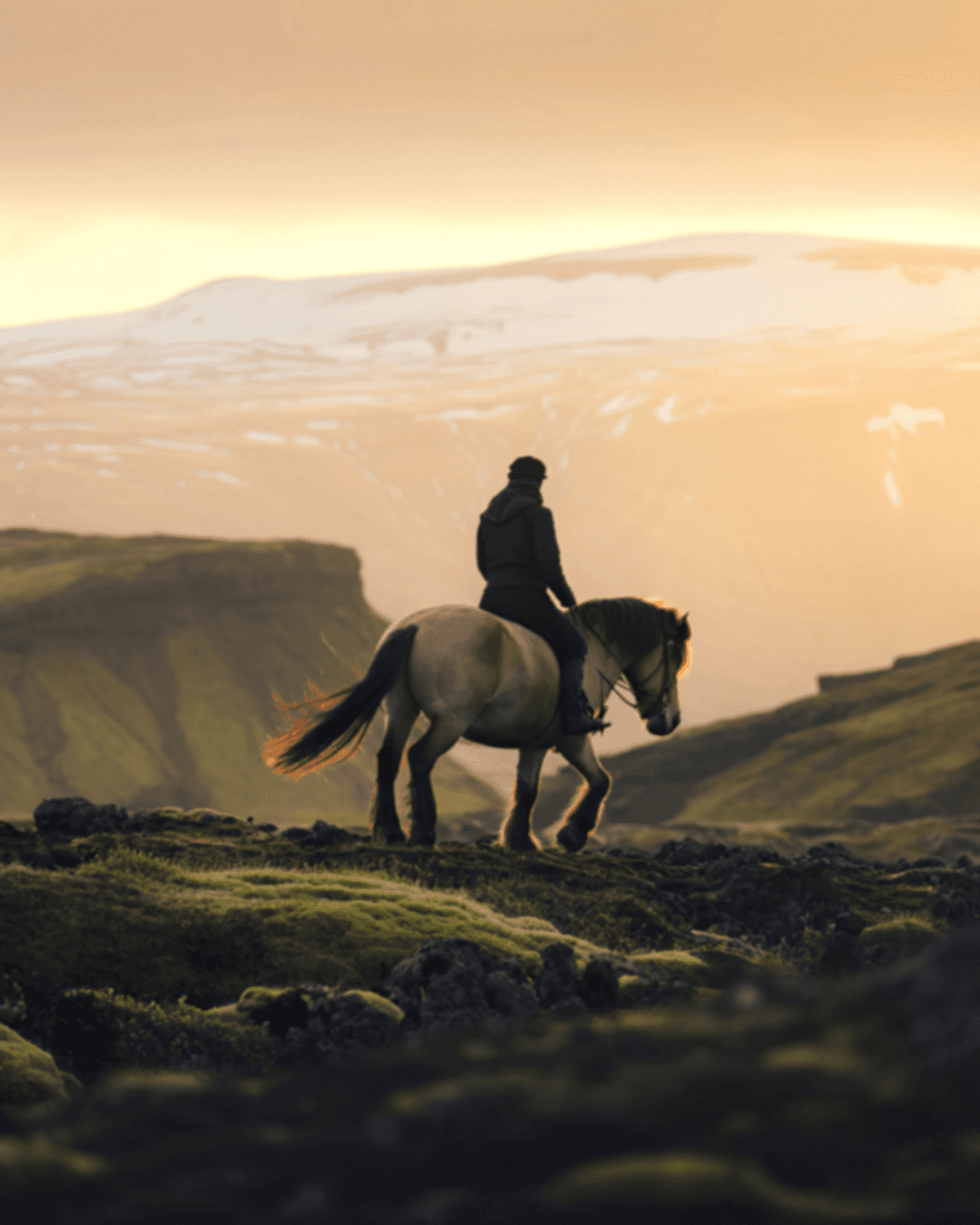 Person riding a horse along an open landscape during an outdoor leisure experience