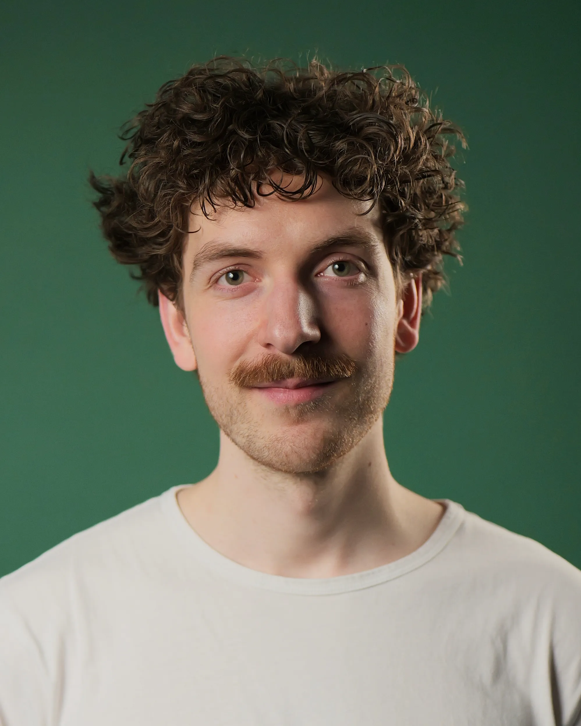 Videoproduktion Dresden Theo Weise schaut in die Kamera. (Profilbild vor grünem Hintergrund)