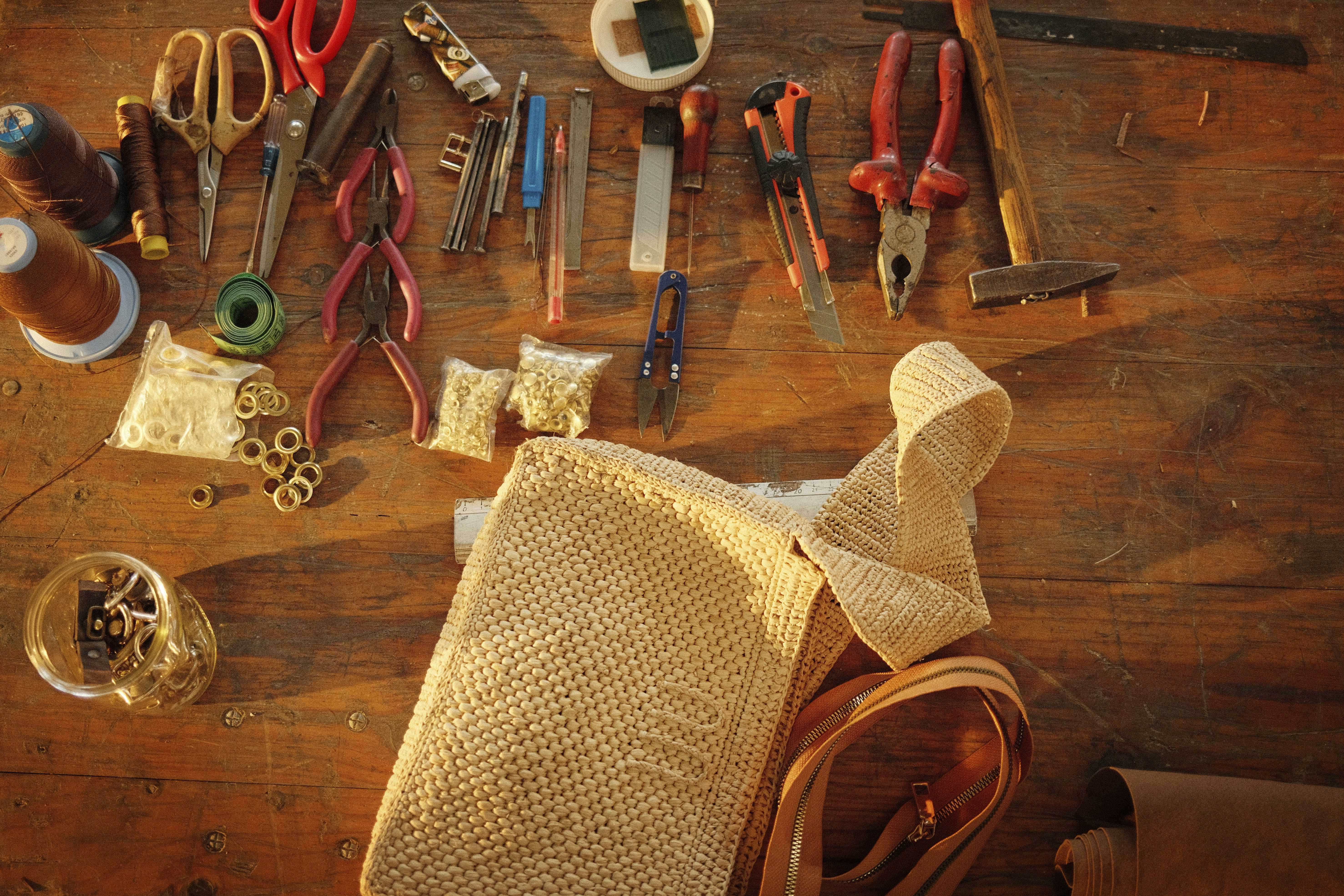 A photo of the leathersmith's station piecing together the JELYNNE cross-body bag