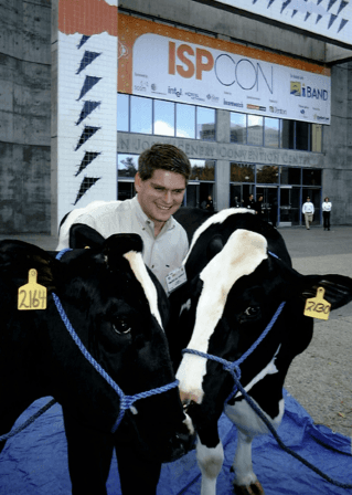 Winner, Donny Simonton, poses with Tucows' two cows at ISPCon in San Diego with two live cows