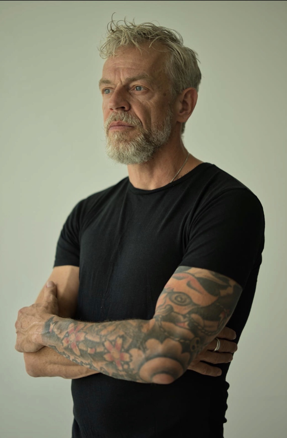 Best ager Model seitlich stehend  arme verschränkt tattovierung Arm