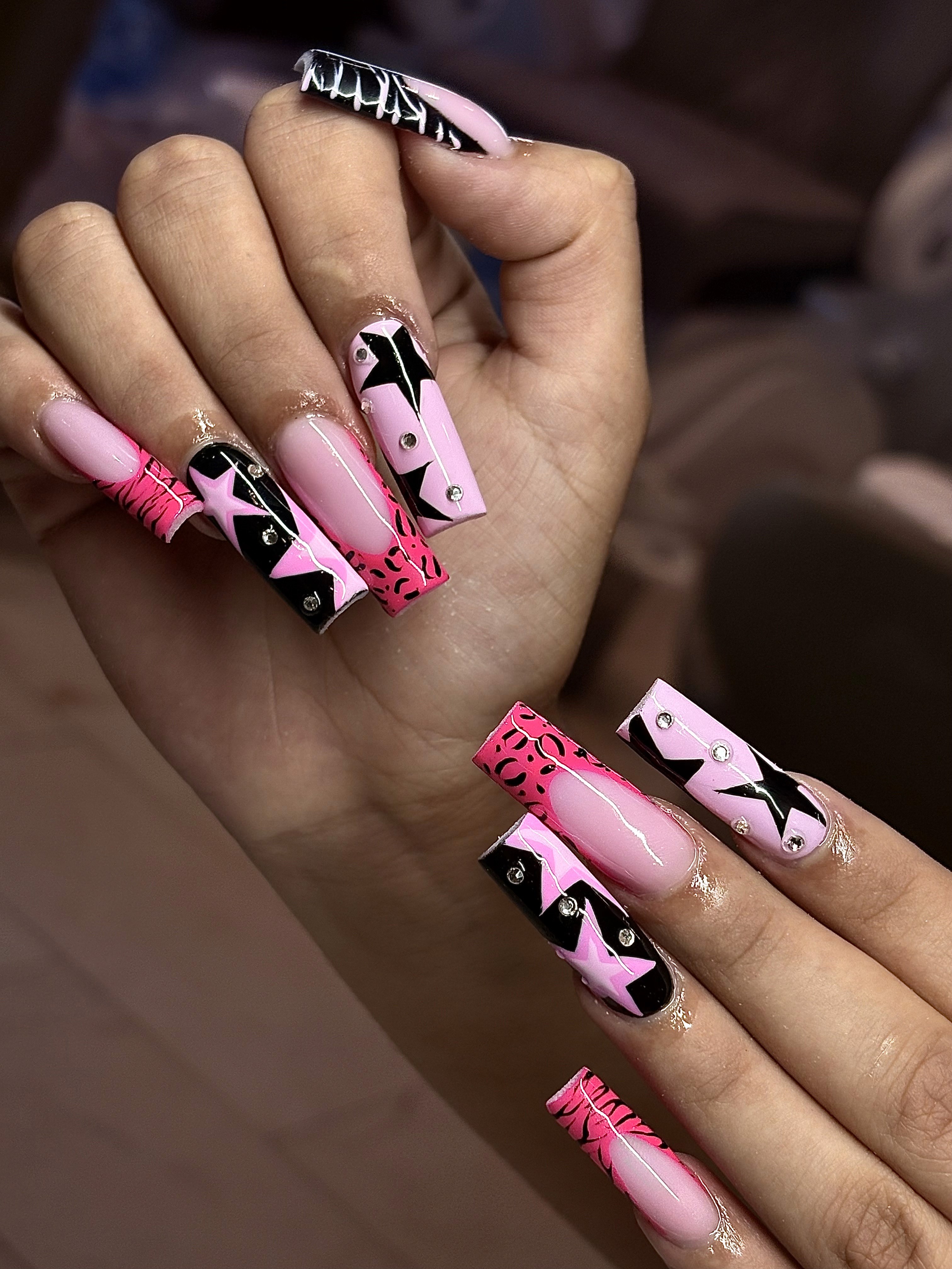 Long acrylic nails with bold pink and black design at Naperville nail salon