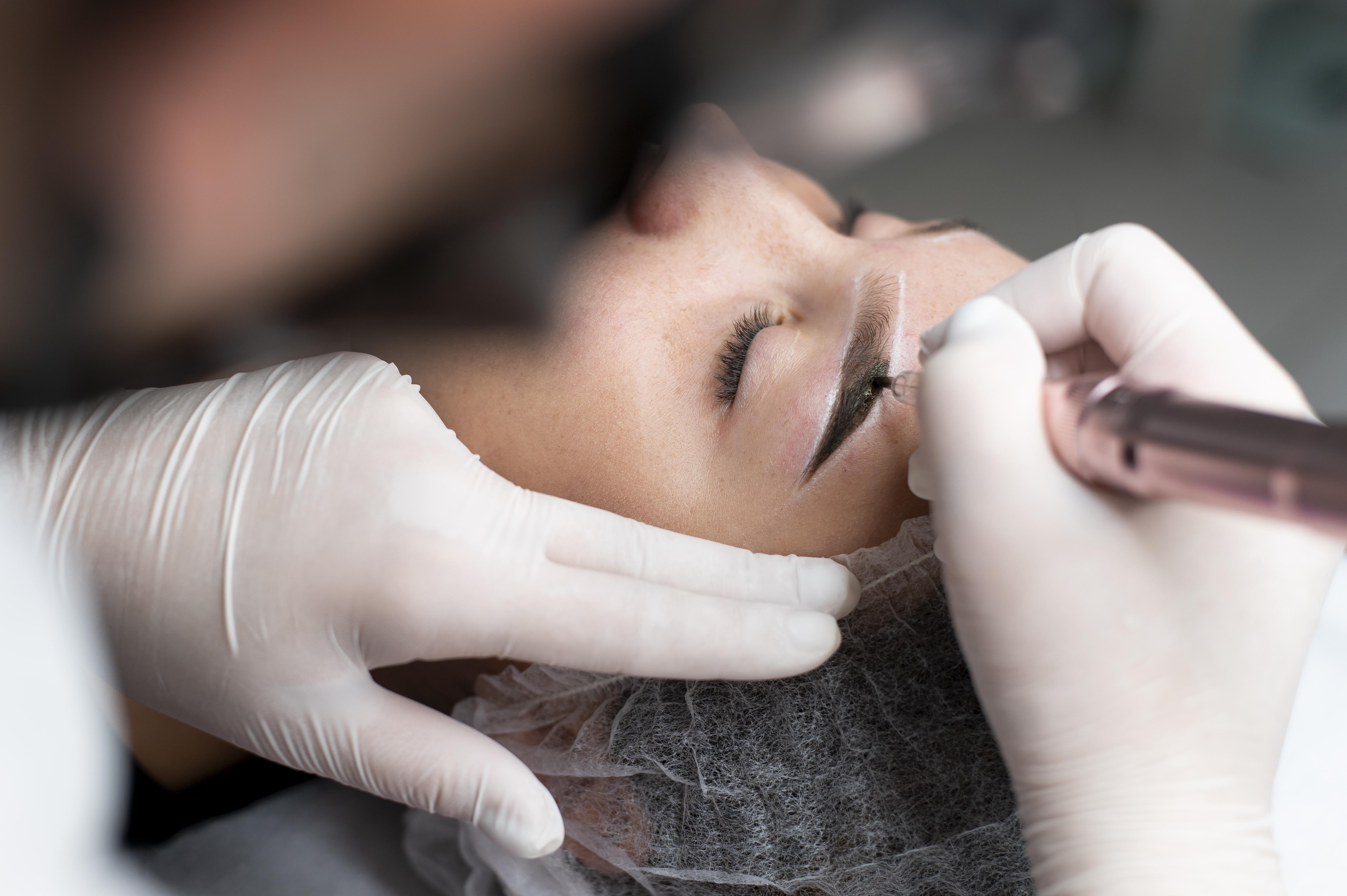 Woman receiving ombré brow treatment, creating soft, gradient eyebrows with permanent makeup.