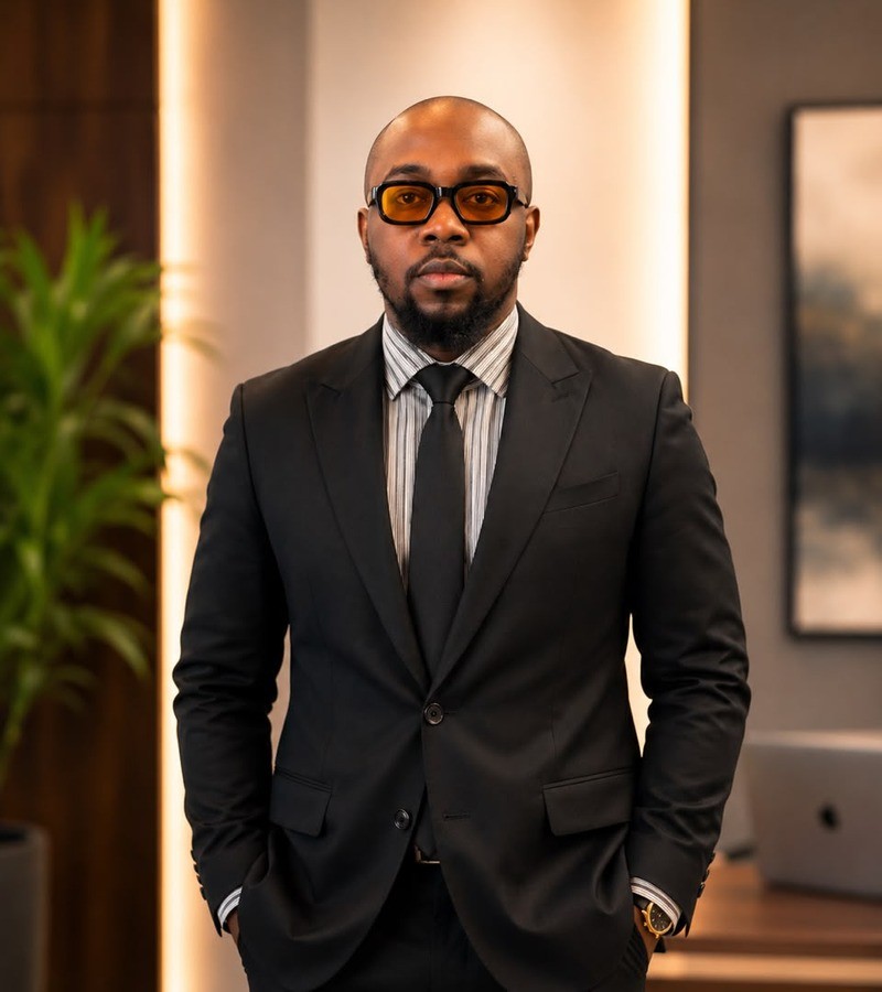 Oocyt clinician in a black suit and amber glasses.