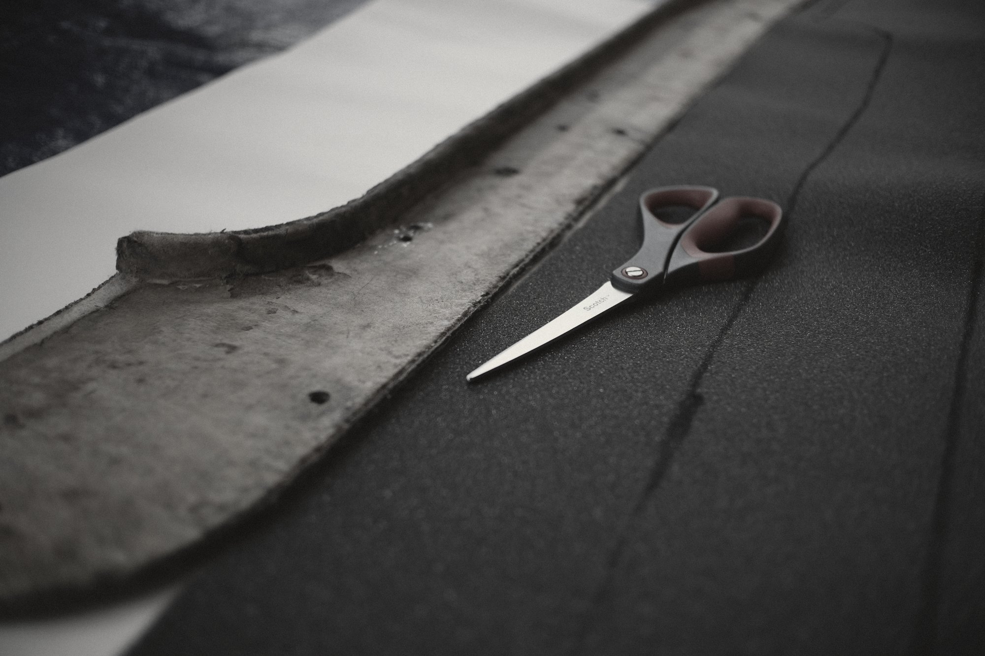 A tailor’s wooden ruler and scissors on black wool