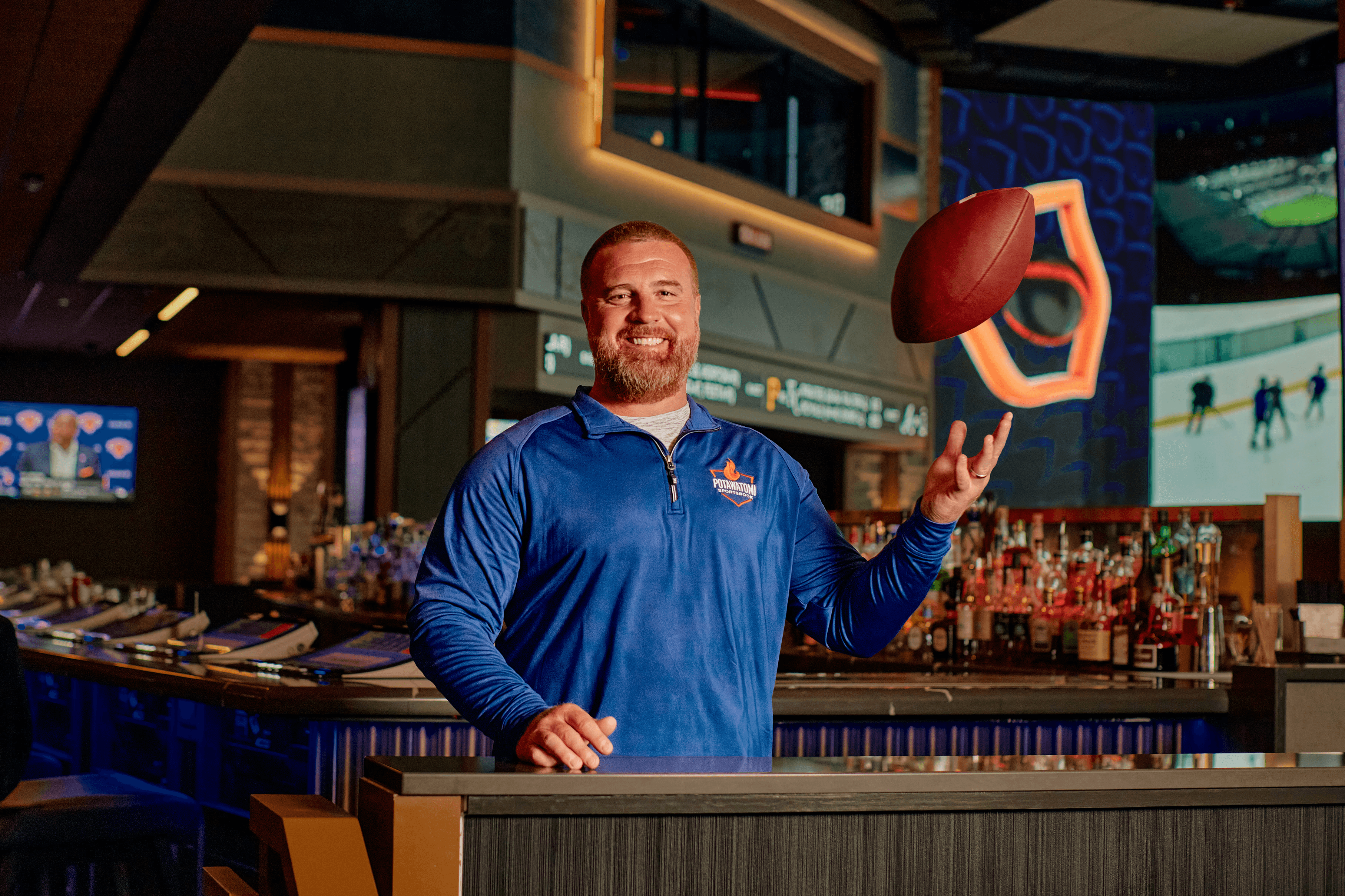John Kuhn tossing football in Sportsbook kitchen bar