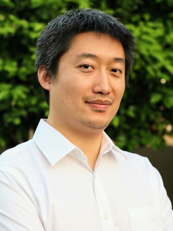 A fast black sports car races down the highway.