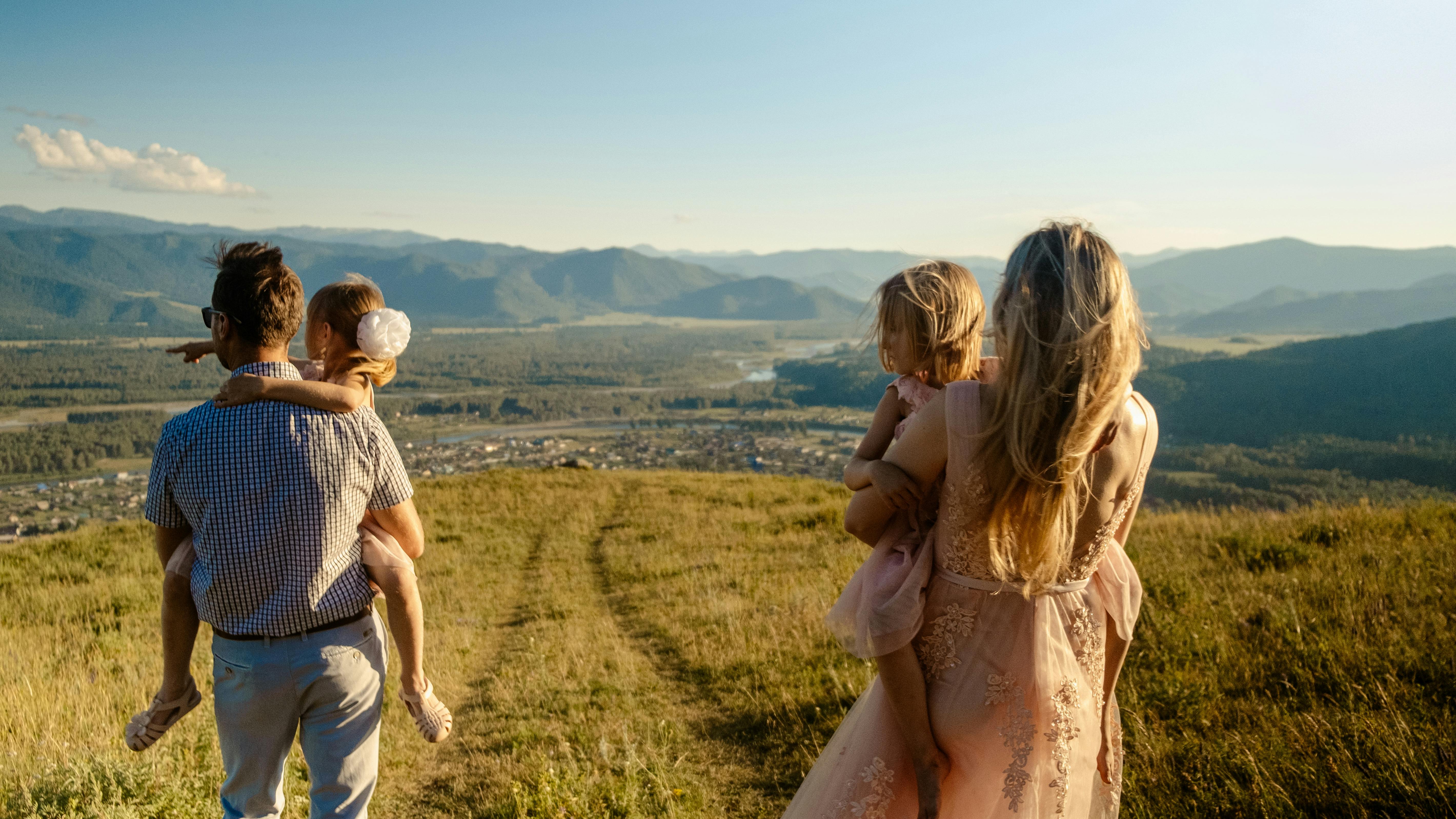 Back view of a family with 2 children looking across the open field.