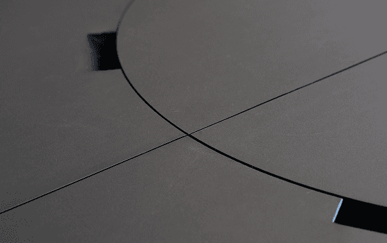 Nahaufnahme der runden SCOPE Tischplatte mit präzise gefrästen Segmentlinien, Teil des modularen Workspace-Systems von Design for Human Nature.