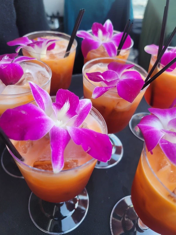 Thai iced tea catering drinks garnished with purple orchids
