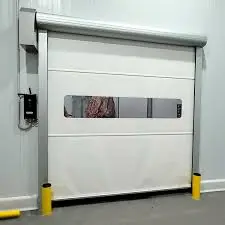 Puerta industrial enrollable de PVC blanca, insonorizada, ignífuga y resistente al viento. Su velocidad de apertura superior a 0.6 m/s la hace perfecta para talleres limpios y seguros.