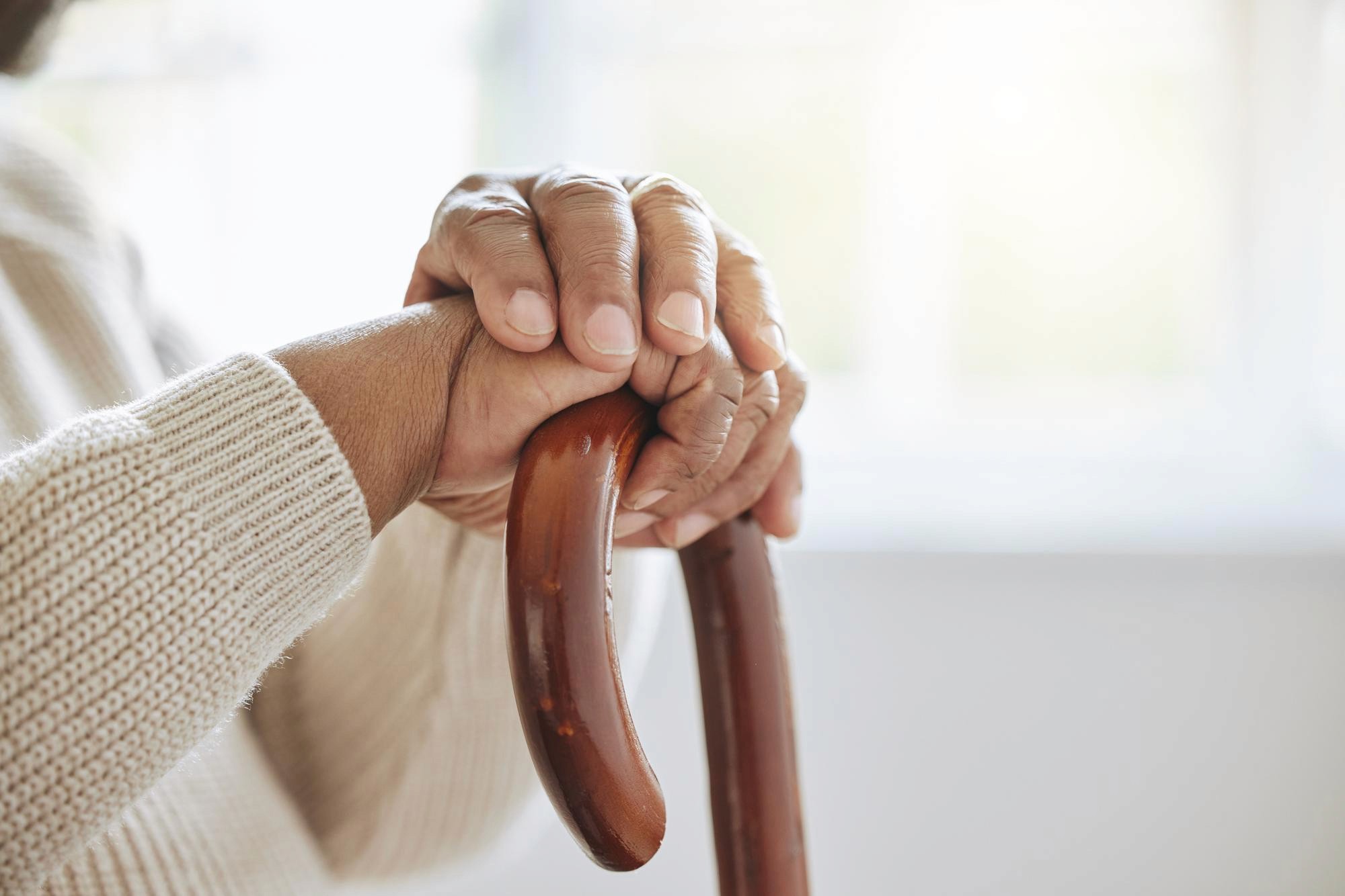 Elderly person holding walking stick
