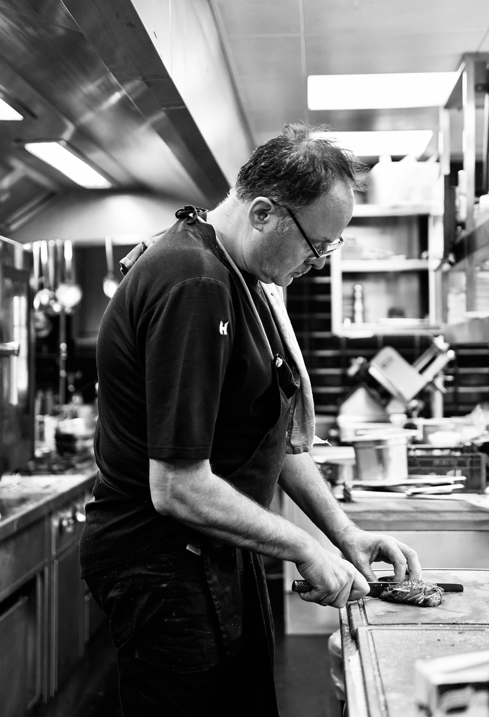 Chef delicately plating a signature dish with precision in the kitchen of La Fontanella