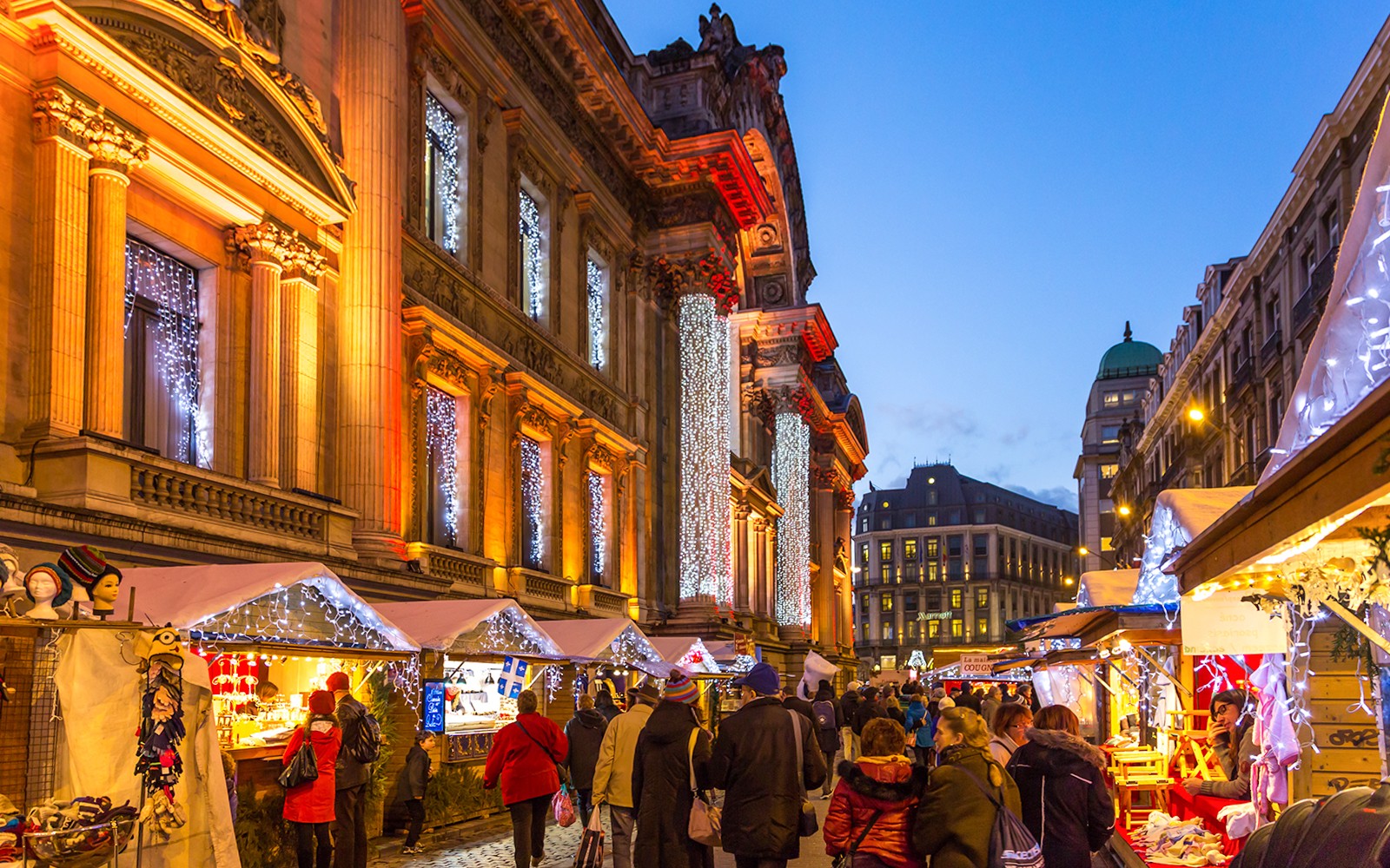 London Christmas market with festive lights and decorated stalls on illuminated street.