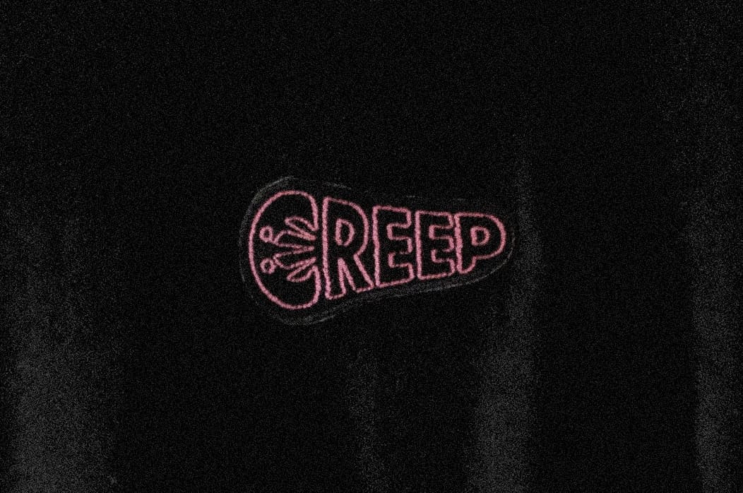 creep embroidered in pink on black t-shirt.