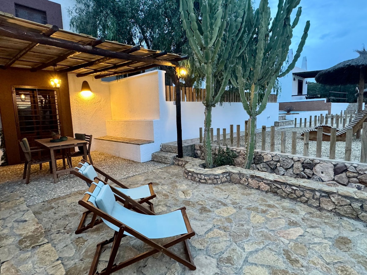 Patio iluminado al anochecer con tumbonas y farolillos